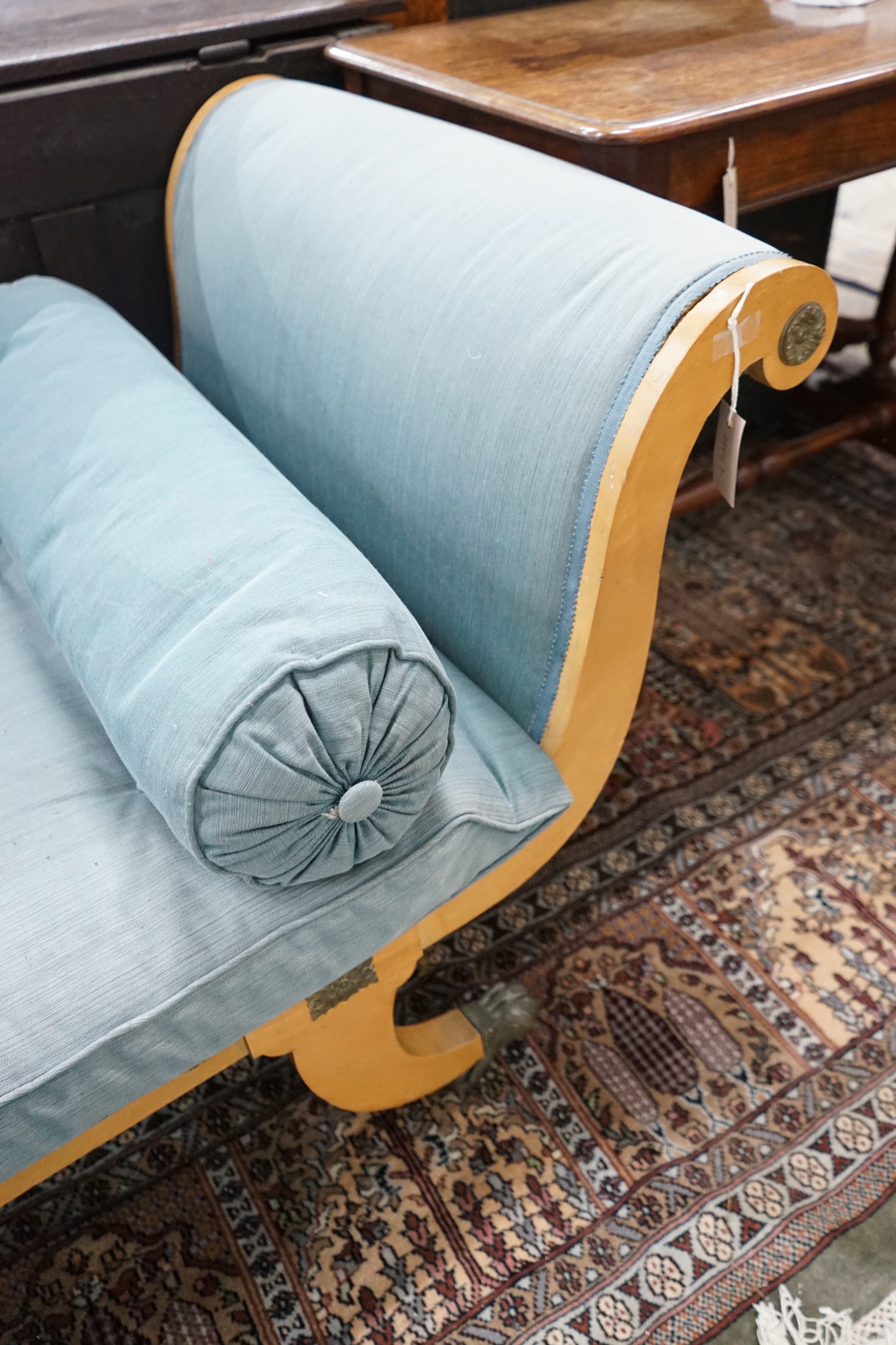 A Biedermeier style gilt metal mounted birch scroll end day bed, length 238cms, depth 75cms, height 73cms.